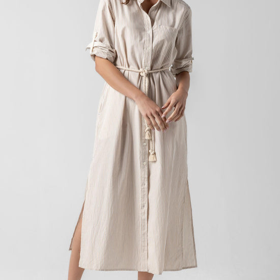 <p>In crisp poplin, the Striped Maxi Shirt Dress offers versatility and effortless ease. Designed with tabs on the sleeves, it can be worn rolled up or down to suit your mood. With tall side slits and a full button-down front, this dress can double as a duster over shorts or white denim for added styling options. An optional natural rope belt allows you to wear it cinched or loose, making it a perfect choice for summer days and beyond.</p> Womens Dress Flax Stripe A1