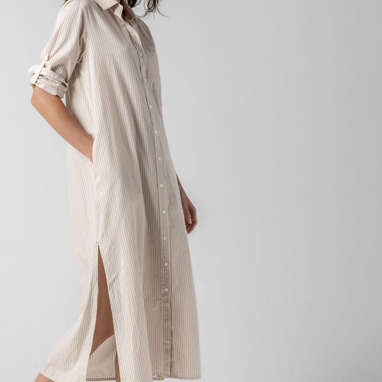 <p>In crisp poplin, the Striped Maxi Shirt Dress offers versatility and effortless ease. Designed with tabs on the sleeves, it can be worn rolled up or down to suit your mood. With tall side slits and a full button-down front, this dress can double as a duster over shorts or white denim for added styling options. An optional natural rope belt allows you to wear it cinched or loose, making it a perfect choice for summer days and beyond.</p> Womens Dress Flax Stripe A2