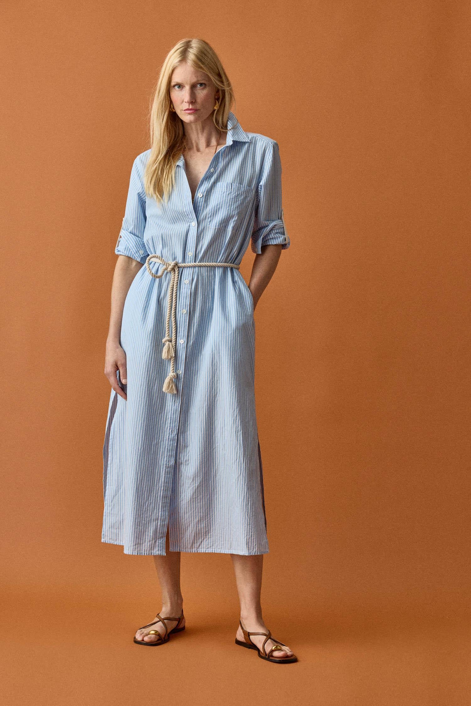 <p>In crisp poplin, the Striped Maxi Shirt Dress offers versatility and effortless ease. Designed with tabs on the sleeves, it can be worn rolled up or down to suit your mood. With tall side slits and a full button-down front, this dress can double as a duster over shorts or white denim for added styling options. An optional natural rope belt allows you to wear it cinched or loose, making it a perfect choice for summer days and beyond.</p> Womens Dress Malibu Stripe C1